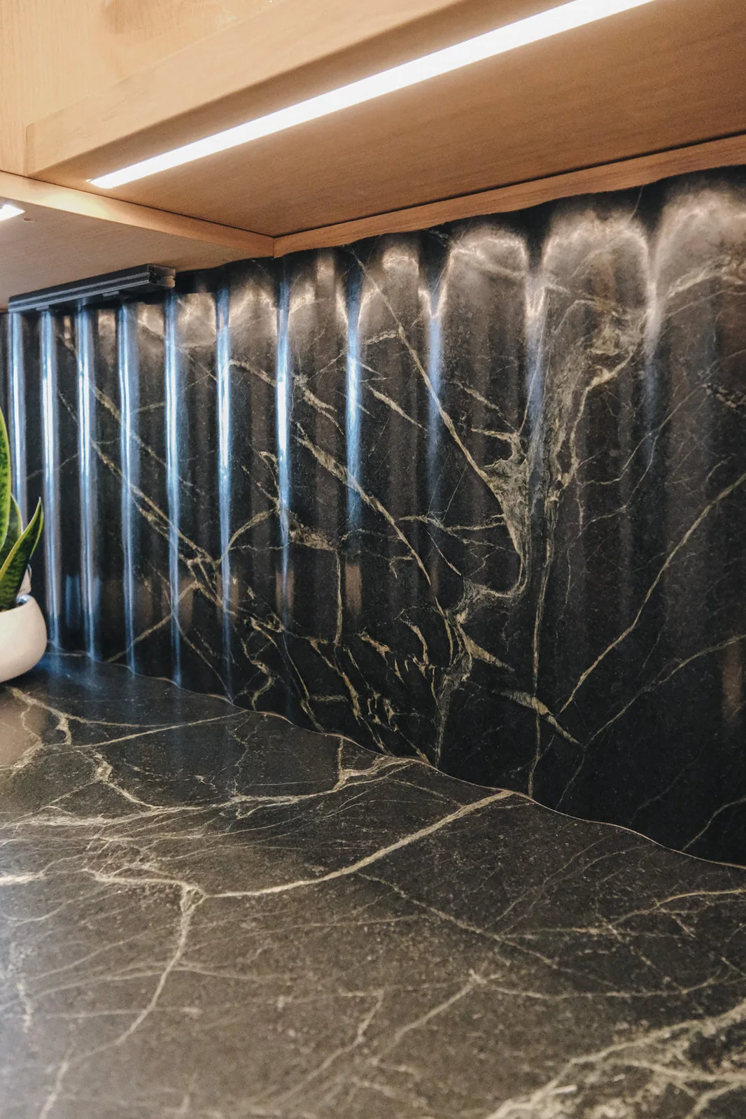 Close view of a dark natural stone slab with pale veining