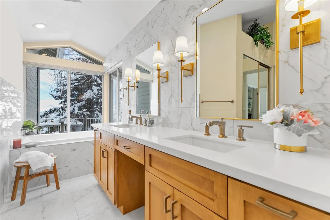 Double vanity in oak with marble surround and brass sconces