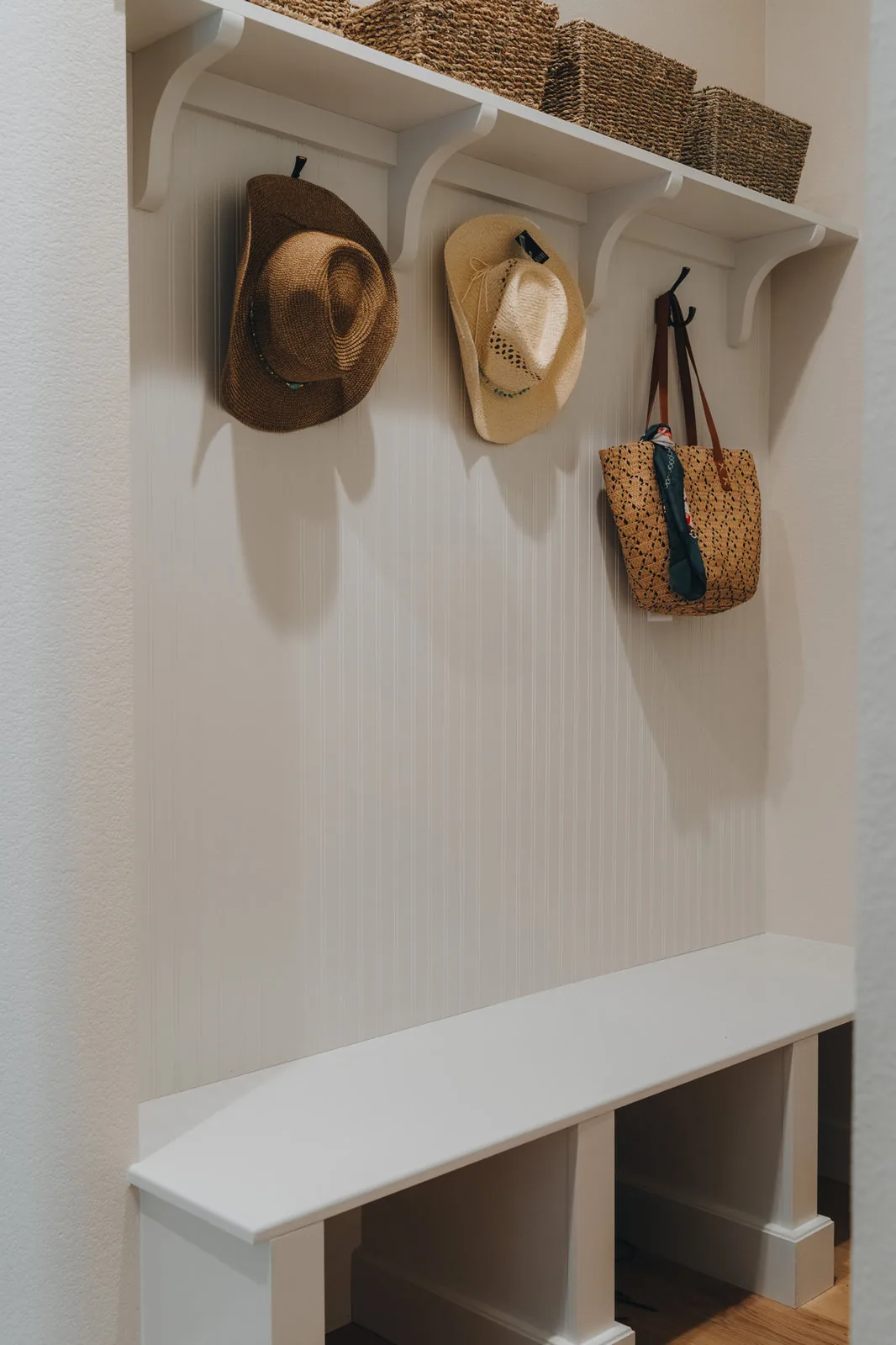 Mudroom bench with a hat shelf and hooks on beadboard
