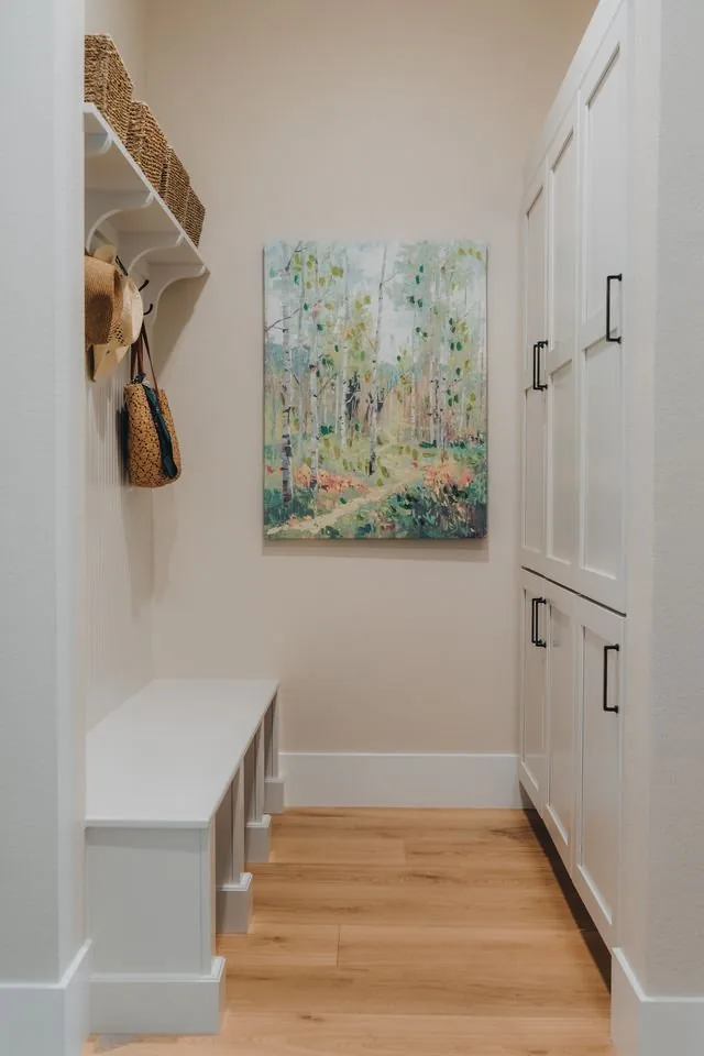 Entry bench and cabinet run in white painted cabinetry