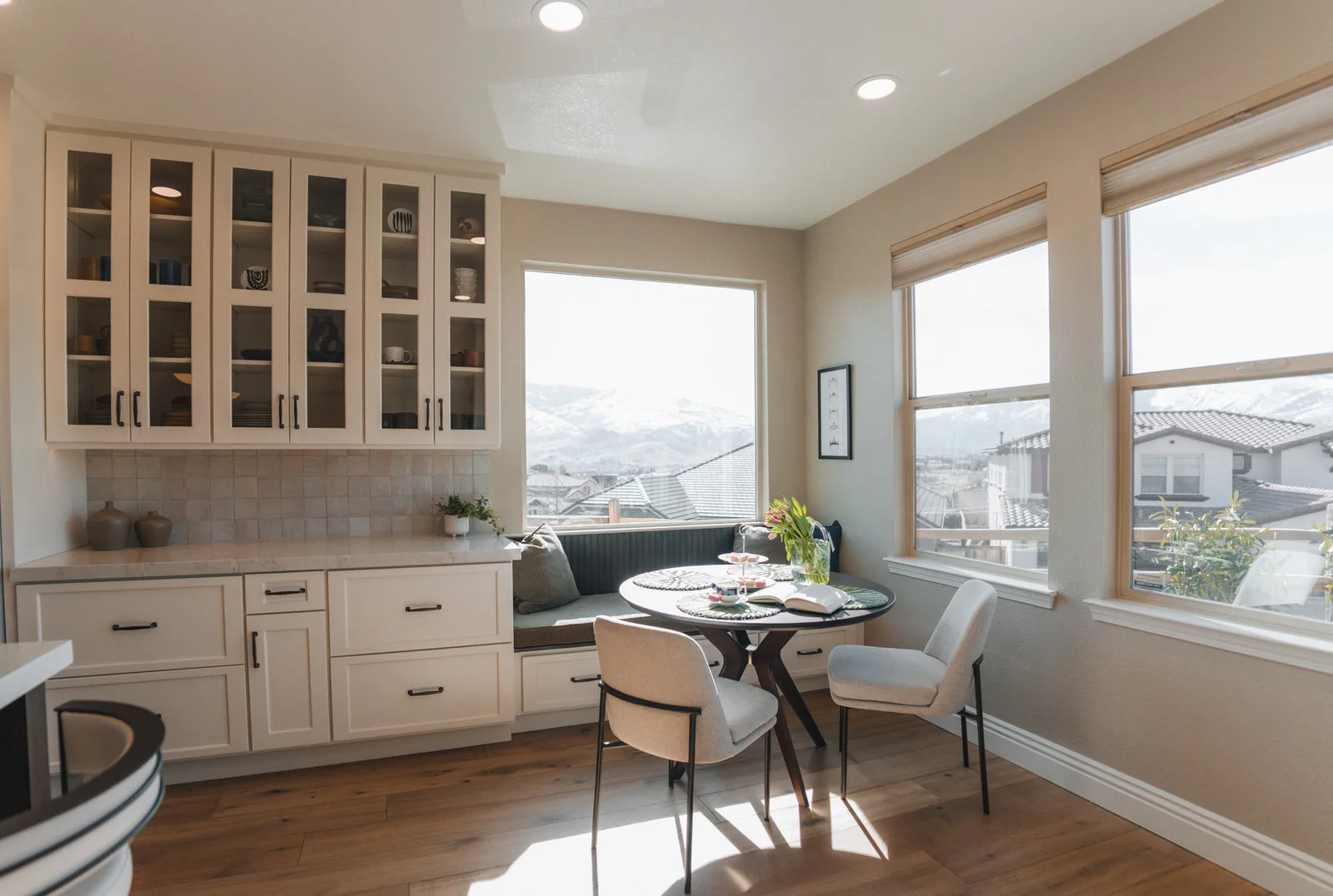 Breakfast nook with a built-in banquette and glass-front cabinets